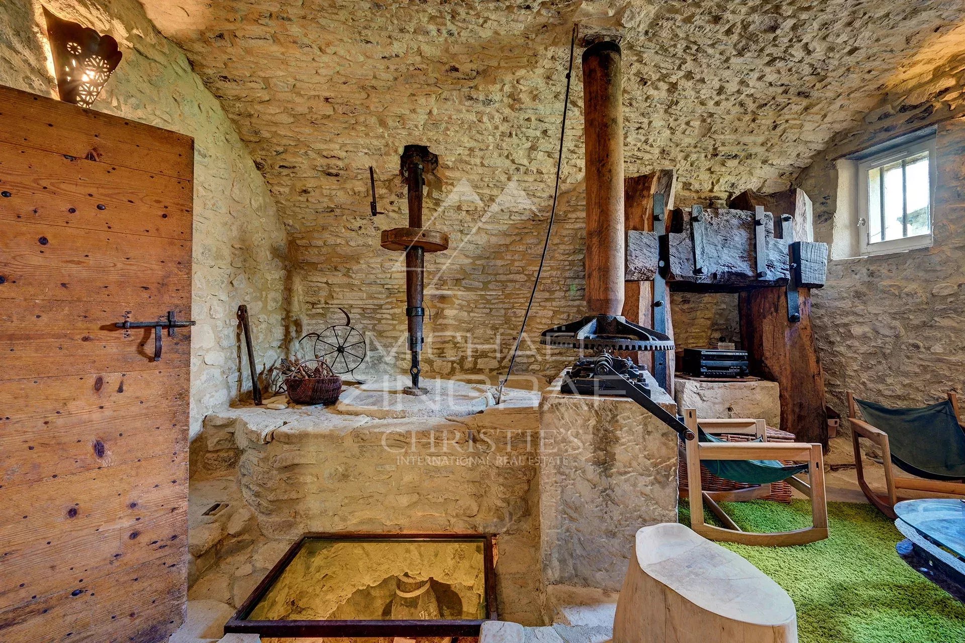 Interior of a renovated 17th-century mill with stone walls and antique equipment.