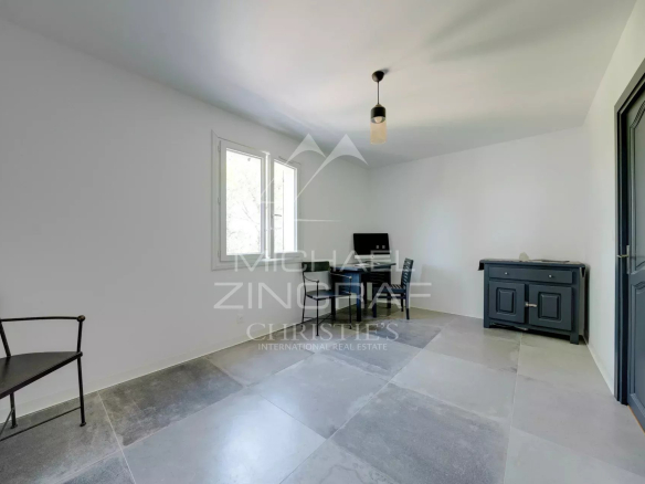 Intérieur d'une villa à Ensuès-la-Redonne, pièce lumineuse avec fenêtres et mobilier minimaliste.