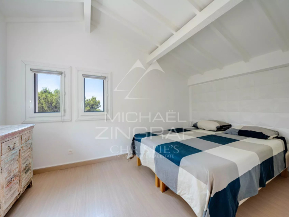 Chambre d'une villa à Ensuès-la-Redonne avec deux fenêtres et un lit double.