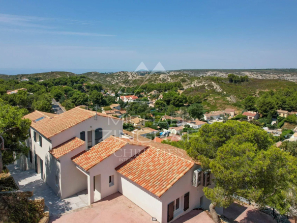 Vue aérienne d'une villa à Ensuès-la-Redonne avec un panorama sur la mer et les collines environnantes.