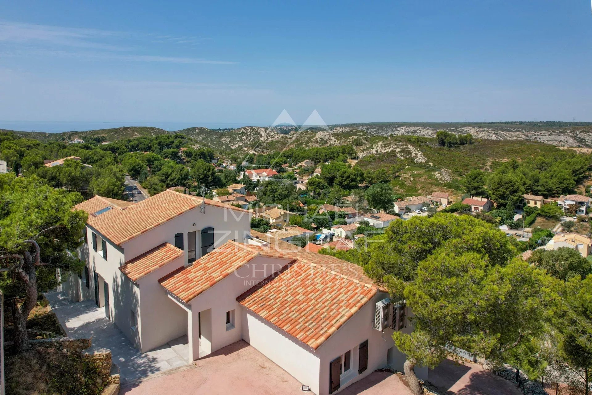 Vue aérienne d'une villa à Ensuès-la-Redonne avec un panorama sur la mer et les collines environnantes.