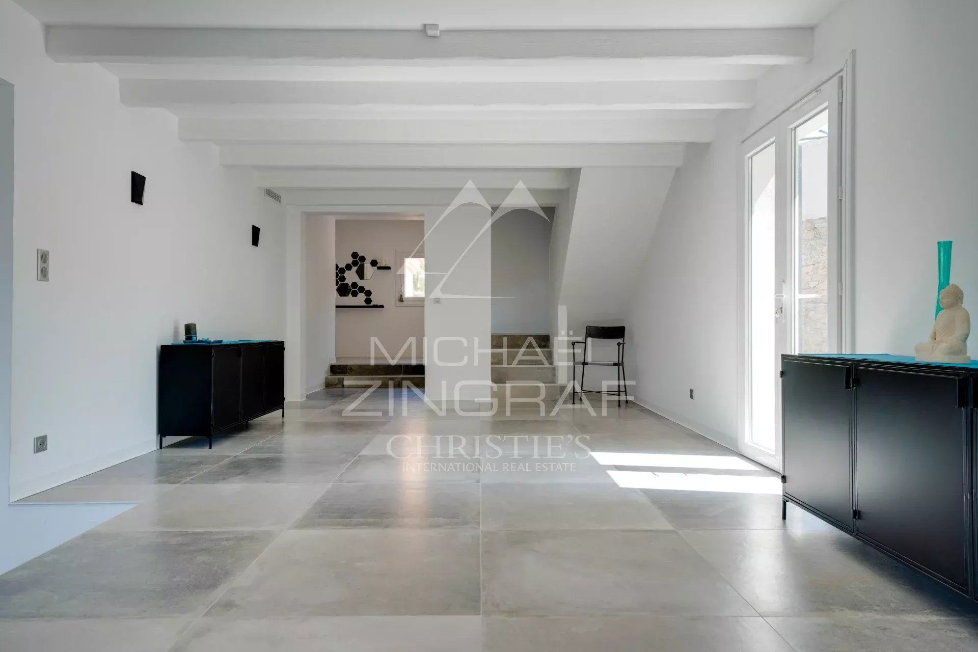 Intérieur d'une villa moderne à Ensuès-la-Redonne avec un sol en carrelage et des murs clairs.