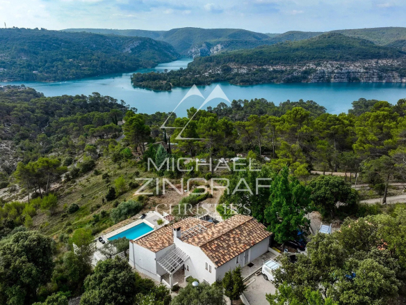 Vue panoramique sur le lac d'Esparron et les Gorges du Verdon, avec une maison et une piscine.