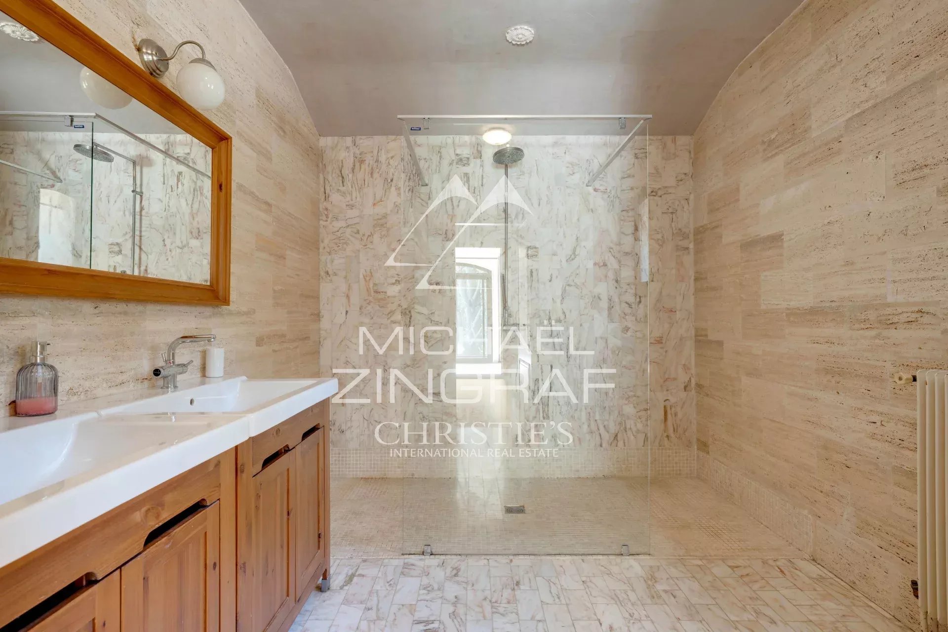 Modern bathroom in a Provençal property Spacious bathroom with walk-in shower and wooden vanity, marble decoration.