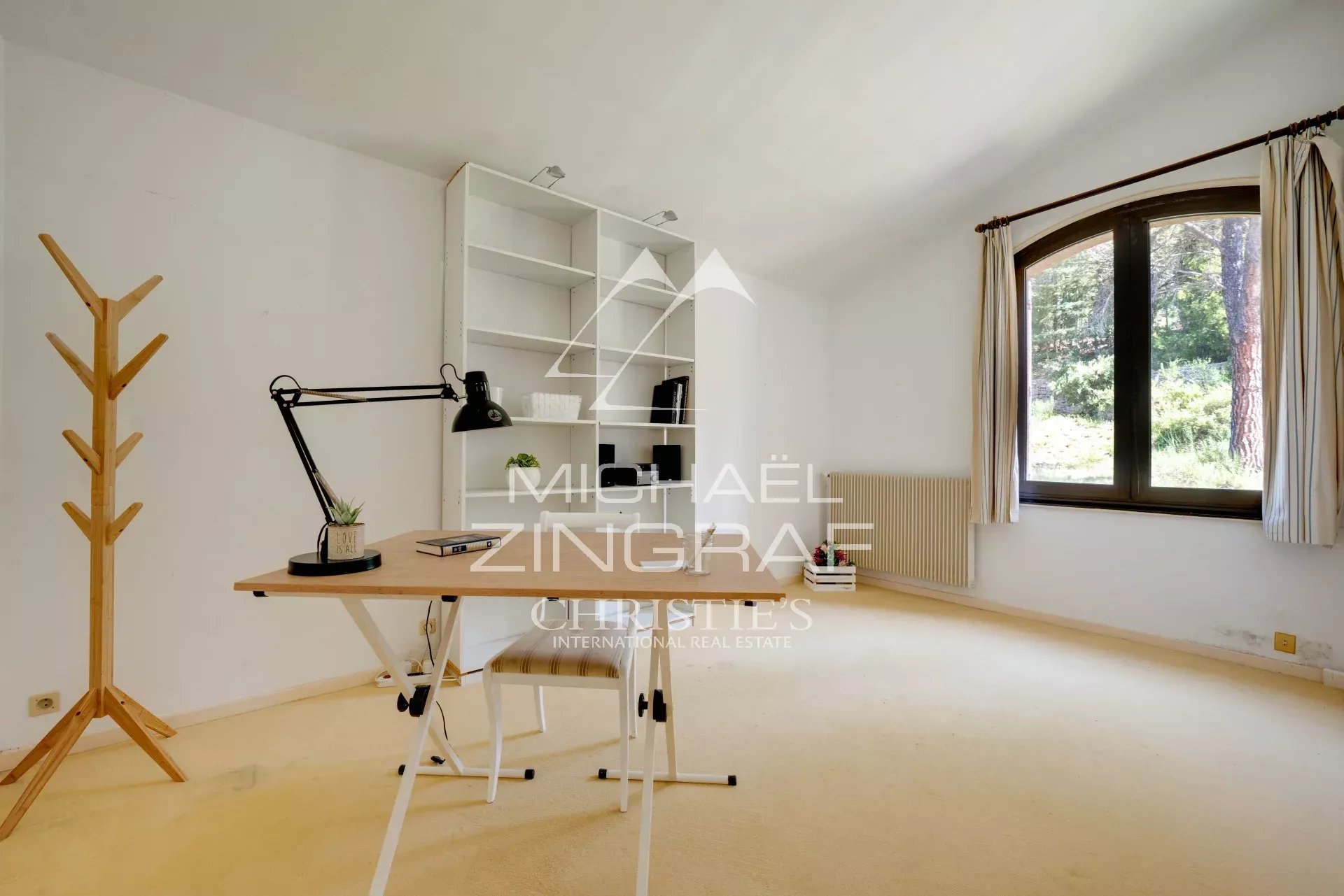 Office in a 1970s Provençal house Interior of a 1970s house with an office and a window overlooking a park.