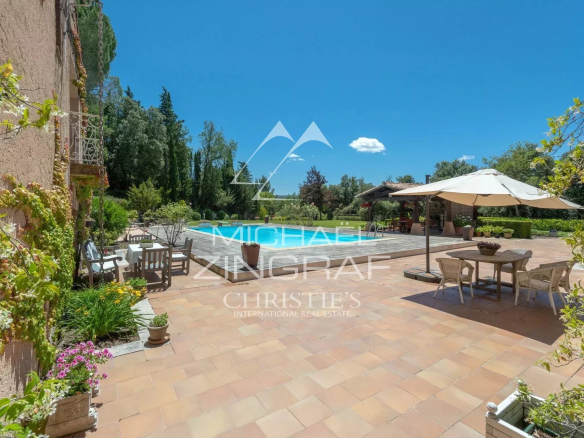 Sunny terrace with swimming pool and parasol in a 2.7 hectare park near Aix-en-Provence.