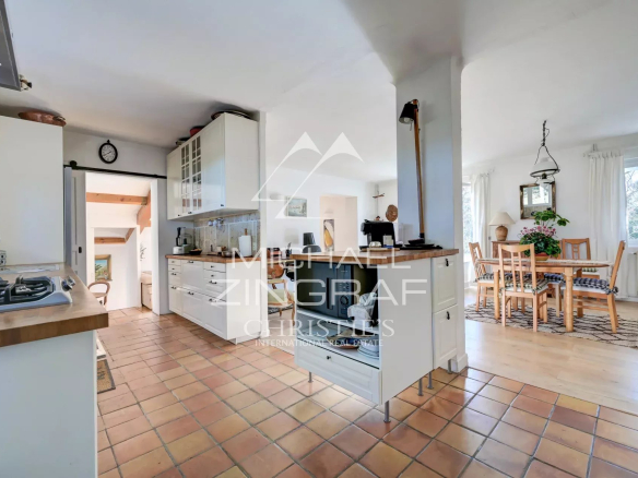 Intérieur d'une maison avec cuisine moderne et salle à manger lumineuse.