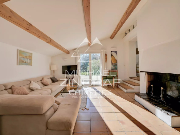 Intérieur d'une maison lumineuse avec un salon confortable et une cheminée.