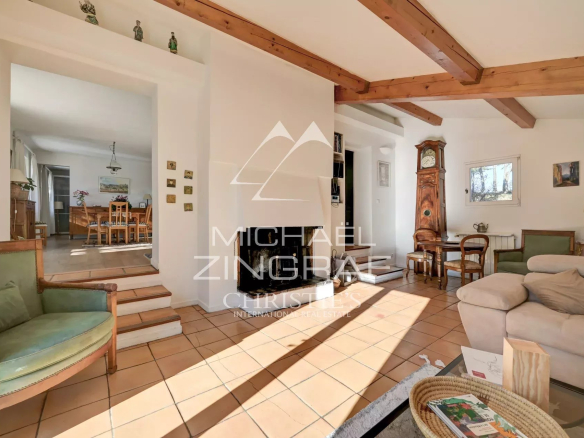 Intérieur lumineux d'une maison avec poutres apparentes et mobilier en bois.