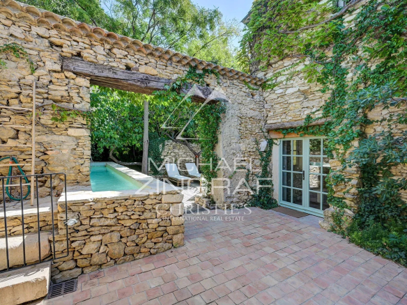 View of a renovated silkworm farm with swimming pool and stone walls, La Fare-les-Oliviers, Provence.