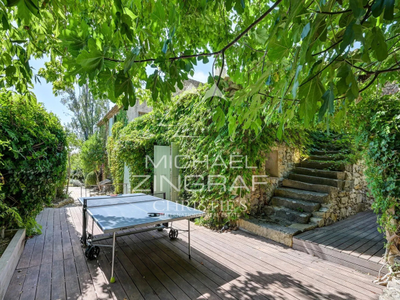 Wooden terrace with ping-pong table and lush vegetation near a renovated silkworm farm