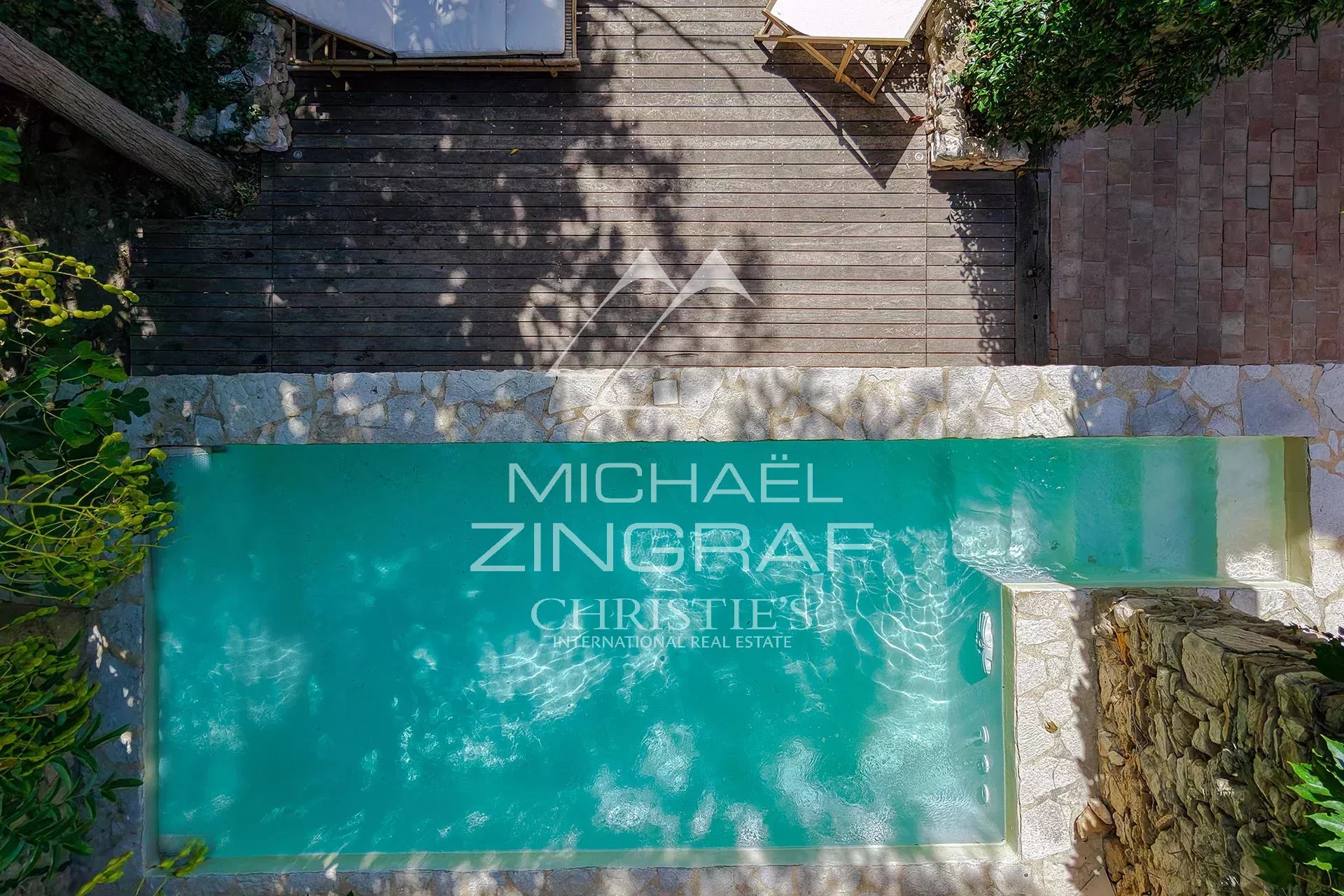 Magnanerie swimming pool renovated Aerial view of a swimming pool in a renovated property with a wooden area around it.