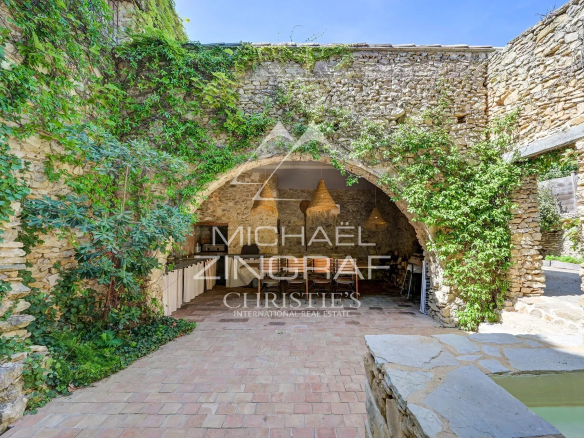 Interior of a renovated silkworm farm with stone walls and climbing plants.