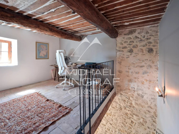 Interior of a renovated silkworm farm with exposed beams and a bright workspace.