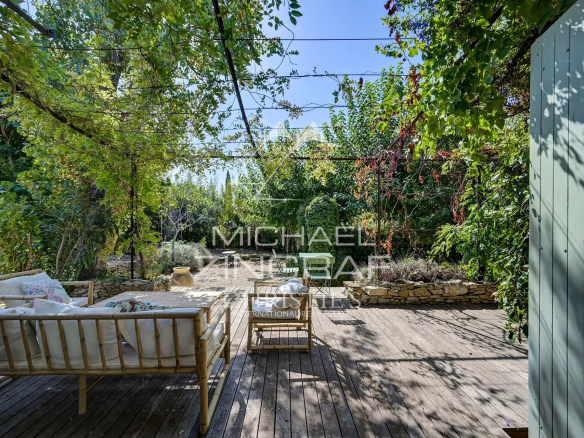 Wooden terrace with garden furniture in a green space