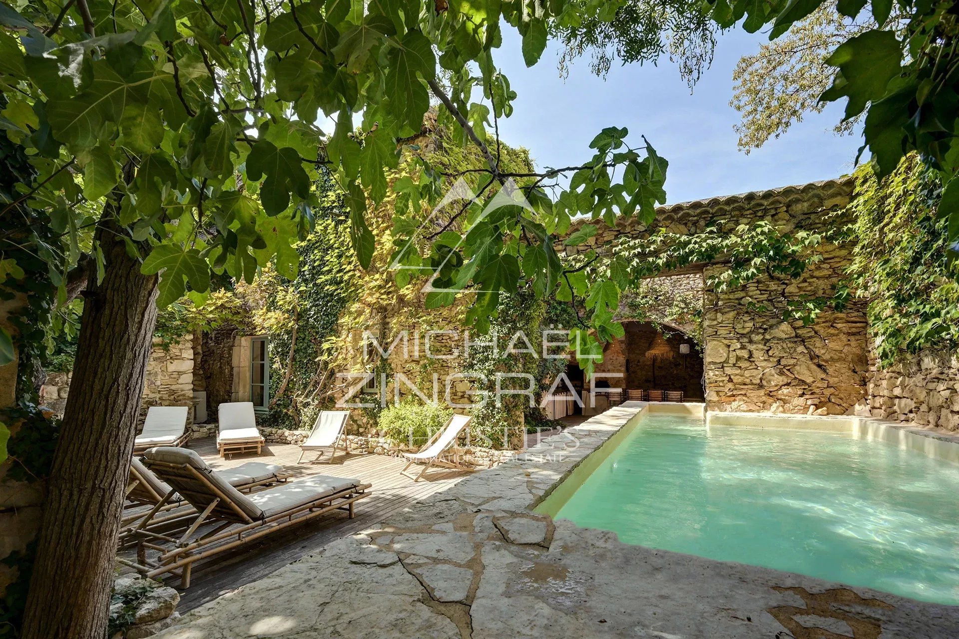 Renovated silkworm farm with swimming pool Swimming pool surrounded by greenery and ancient stones in a renovated silkworm farm.