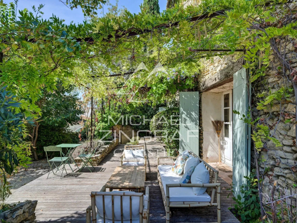 Wooden terrace with garden furniture in a green space, La Fare-les-Oliviers.