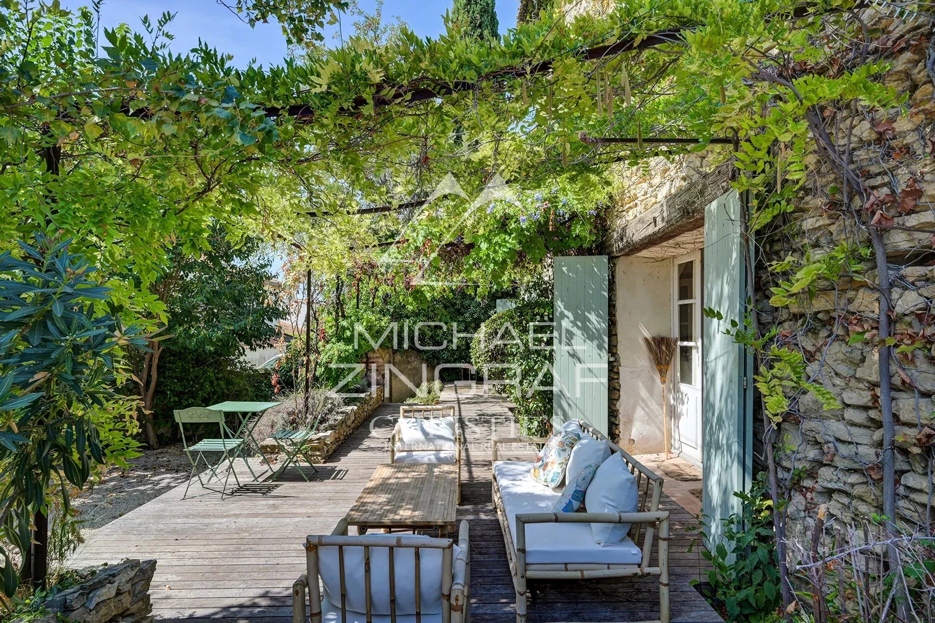Terrace of the renovated silkworm farm Wooden terrace with garden furniture in a green space, La Fare-les-Oliviers.