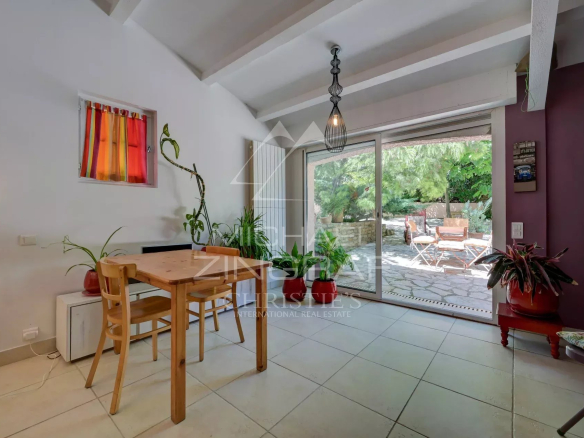 Interior of a villa in La Ciotat with table and chairs, view of the garden.