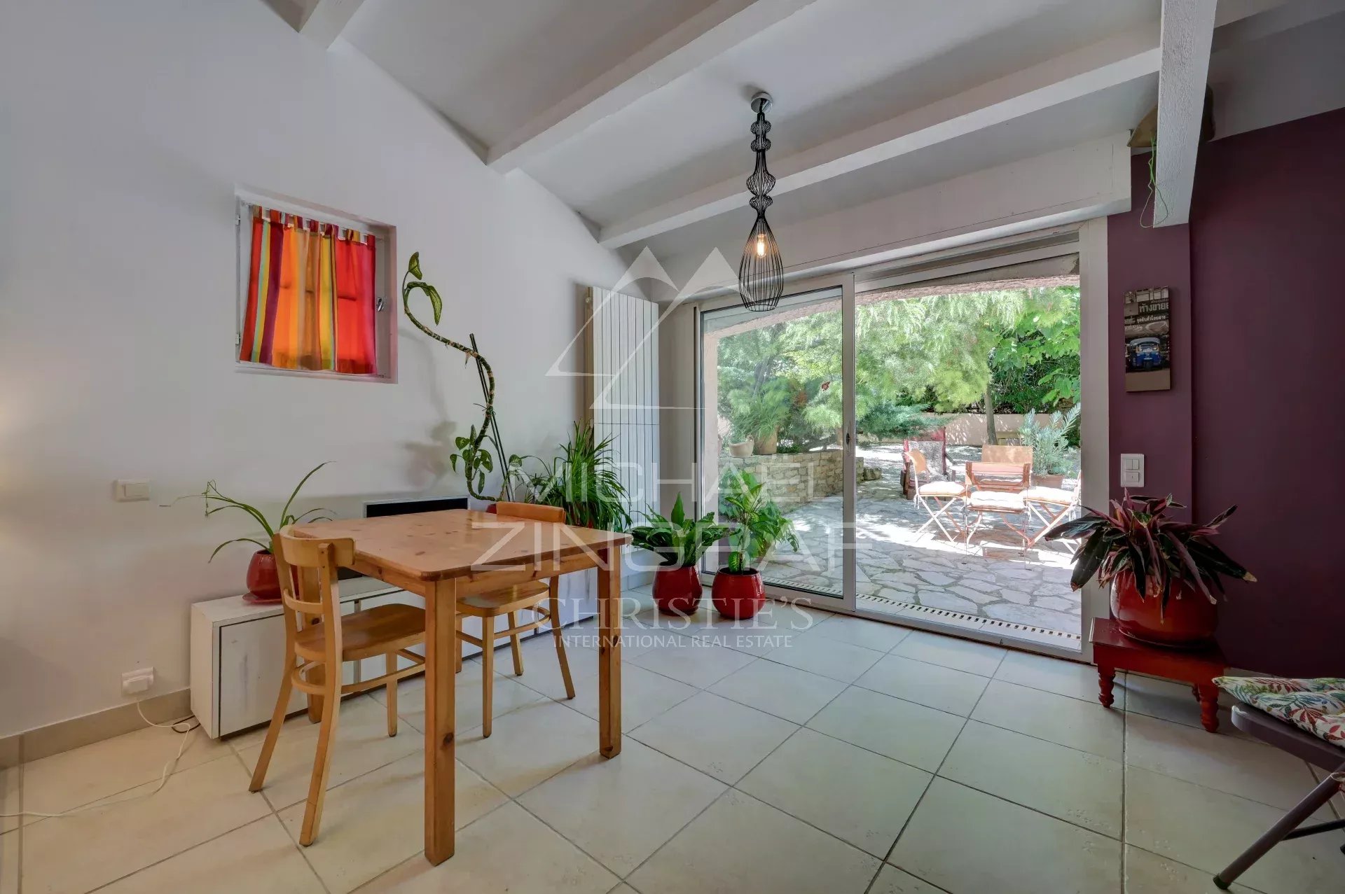 Interior of a villa in La Ciotat Interior of a villa in La Ciotat with table and chairs, view of the garden.