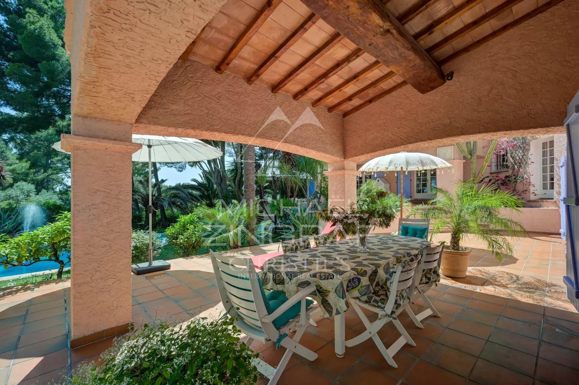 Villa terrace in La Ciotat Terrace of a villa in La Ciotat with table and chairs, surrounded by greenery and parasols.