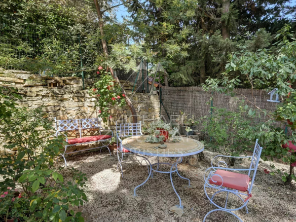 Outdoor space with wrought iron table and chairs in a landscaped garden in La Ciotat.
