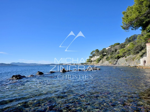 View of the sea and rocks at Cap Brun, Toulon, with trees in the background.