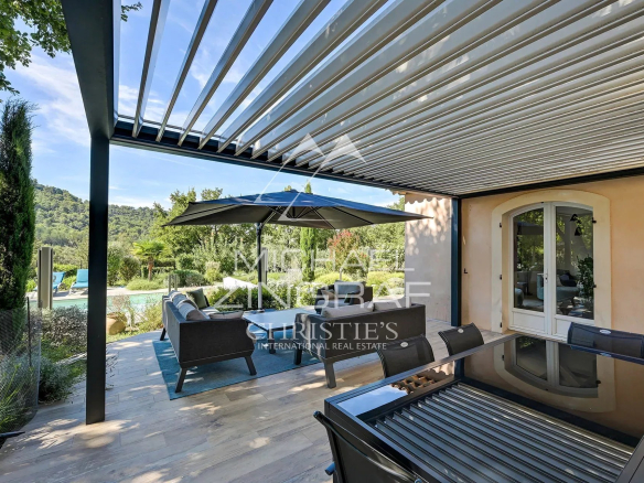 Terrasse d'une propriété à Ansouis avec mobilier extérieur et vue sur la nature environnante.