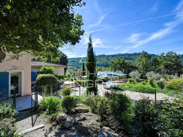 Propriété paysagée avec piscine à Ansouis, entourée de verdure et vue sur la campagne provençale.