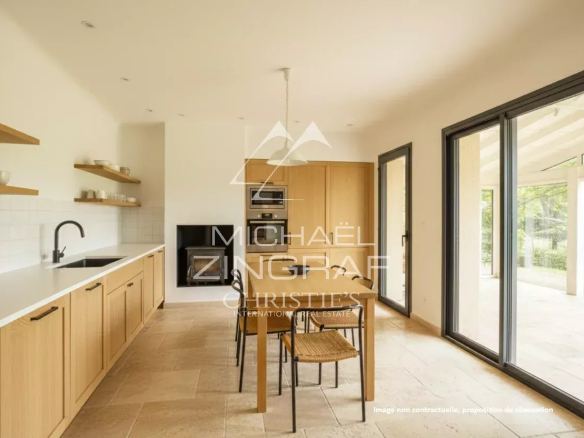 Cuisine moderne avec table à manger et accès à un espace lumineux.