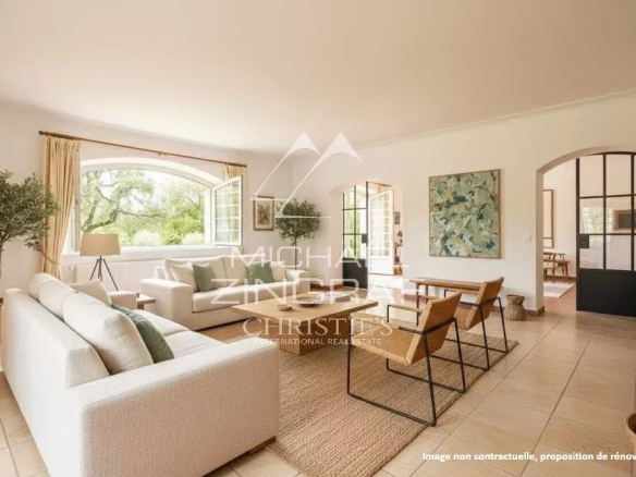 Intérieur d'une bastide avec un salon lumineux et des grandes fenêtres, décoré avec des meubles modernes.