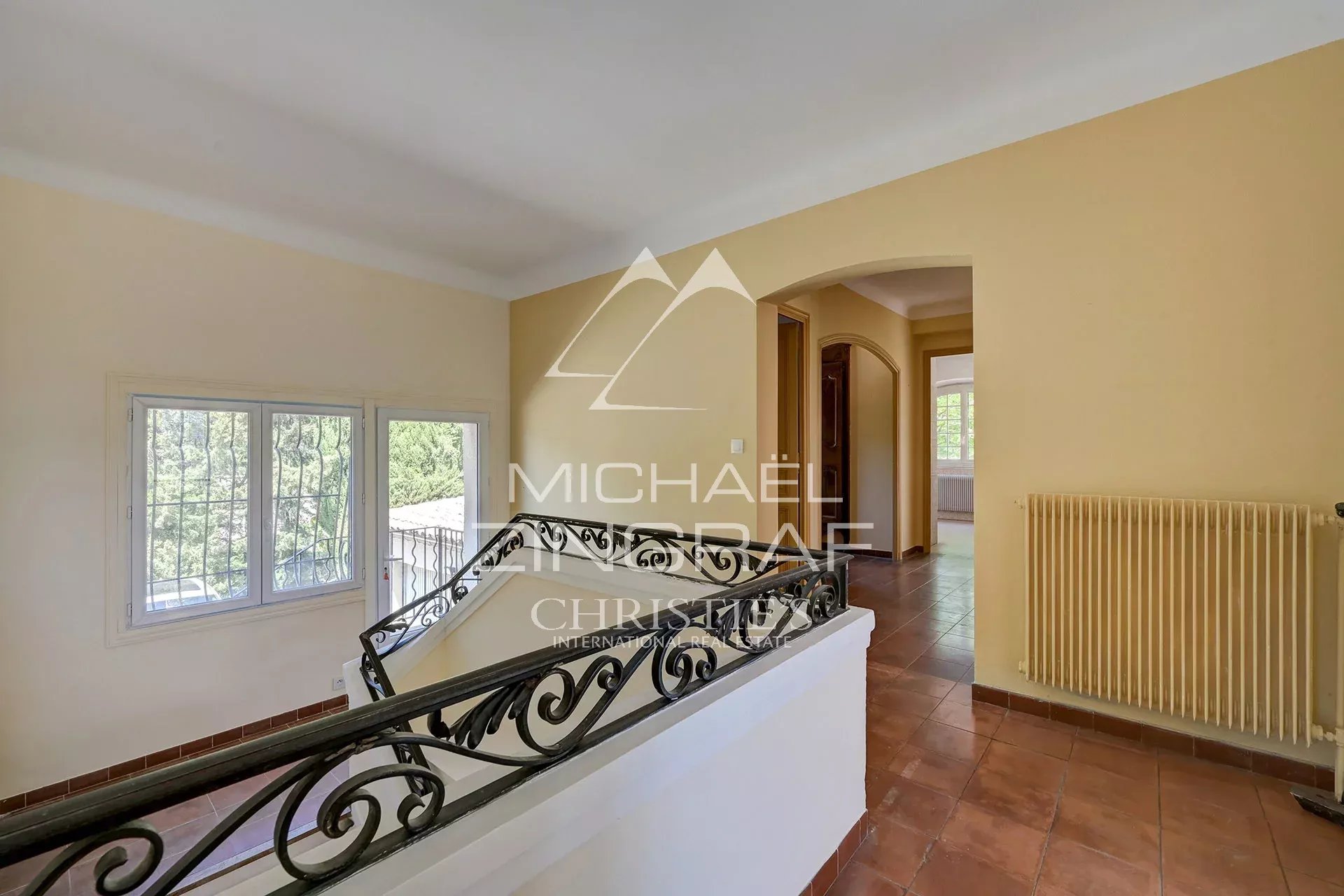 Intérieur d’une bastide à Aix-en-Provence Intérieur d'une bastide avec un escalier et des fenêtres donnant sur un parc.