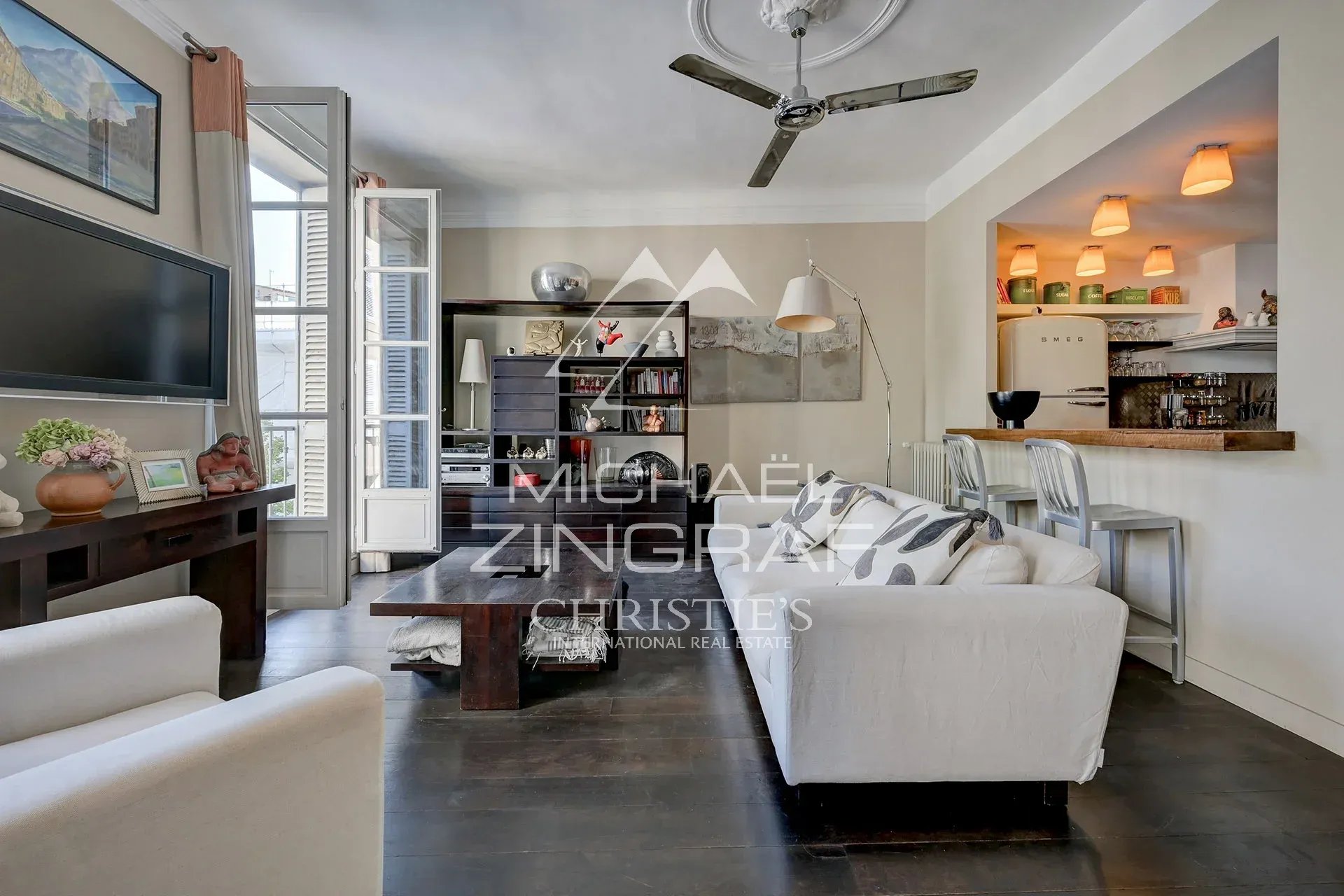 Salon lumineux d'un appartement de 110 m² avec cuisine ouverte et décoration moderne à Aix-en-Provence.