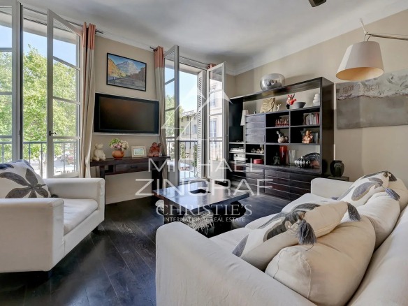 Salon lumineux d'un appartement d'exception à Aix-en-Provence avec fenêtres sur la place des Prêcheurs.
