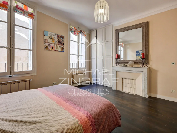 Chambre d'un appartement de 110 m² à Aix-en-Provence avec fenêtre et cheminée décorative.