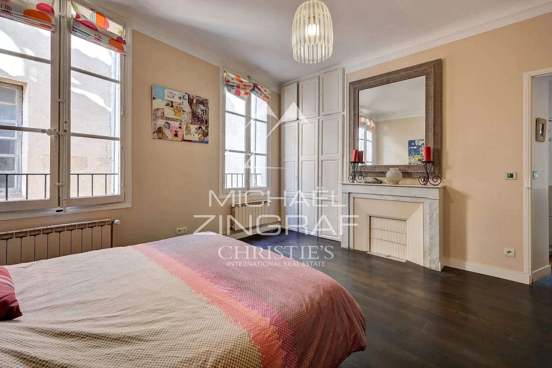 Chambre d'un appartement de 110 m² à Aix-en-Provence avec fenêtre et cheminée décorative.