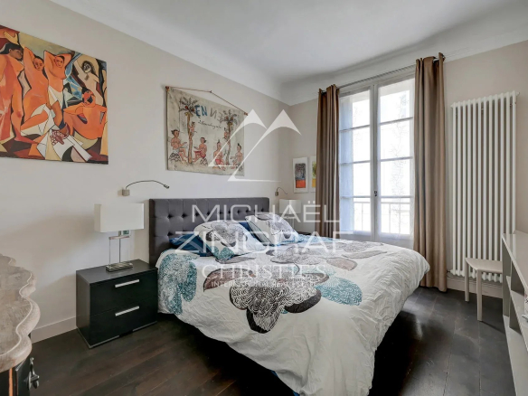 Chambre d'un appartement à Aix-en-Provence avec un lit double et des œuvres d'art au mur.