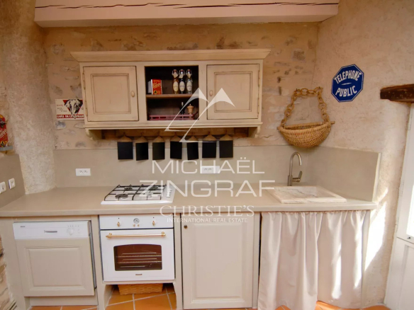 Renovated kitchen of a 17th century mill in Forcalquier, with modern elements and old-world charm.