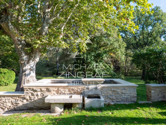 A renovated 17th-century mill surrounded by greenery in Forcalquier.
