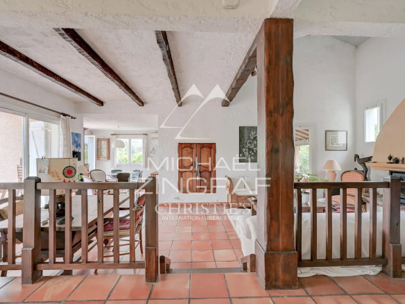 Intérieur d'une maison d'architecte avec poutres apparentes et espace de vie ouvert.