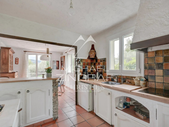 Cuisine d'une maison d'architecte à Aubagne avec des carreaux colorés et des fenêtres lumineuses.
