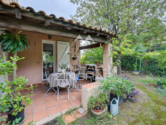 Terrasse d'une maison d'architecte avec table et chaises, entourée de verdure à Aubagne.