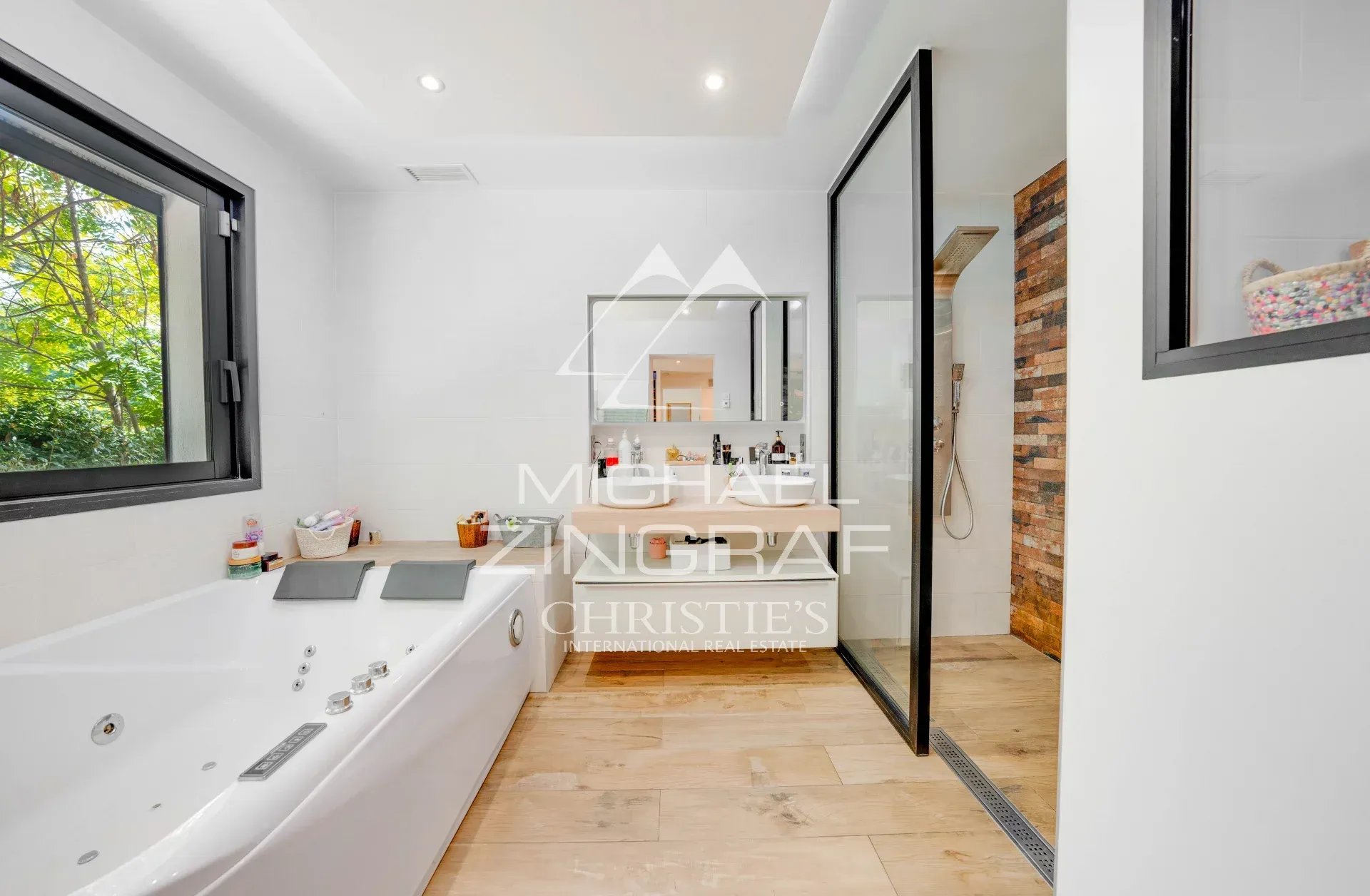 Salle de bain moderne Salle de bain moderne avec baignoire et douche, fenêtres donnant sur la nature.