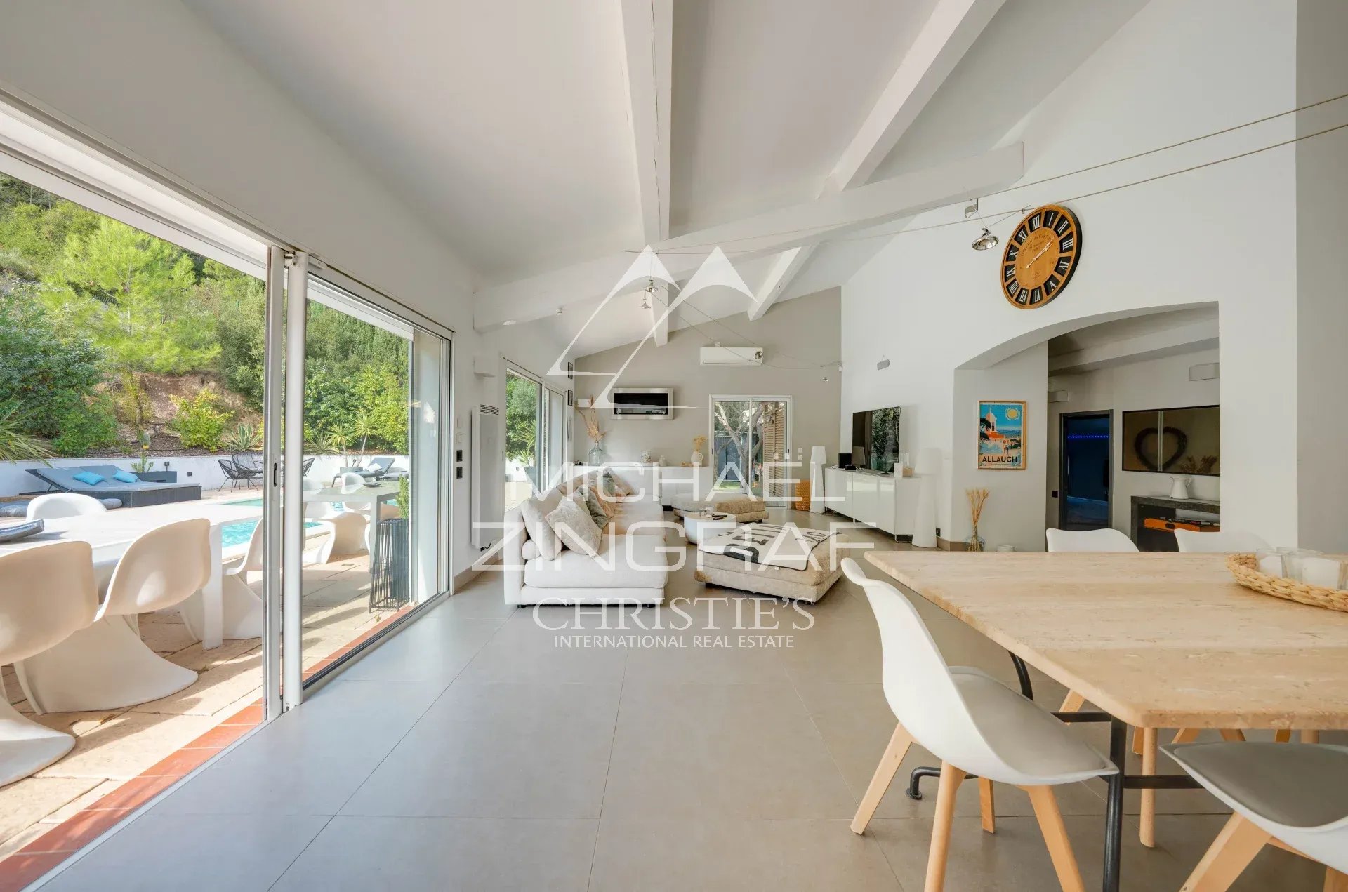 Maison moderne avec piscine à Allauch Intérieur d'une maison moderne avec une salle à manger lumineuse et vue sur une piscine extérieure.