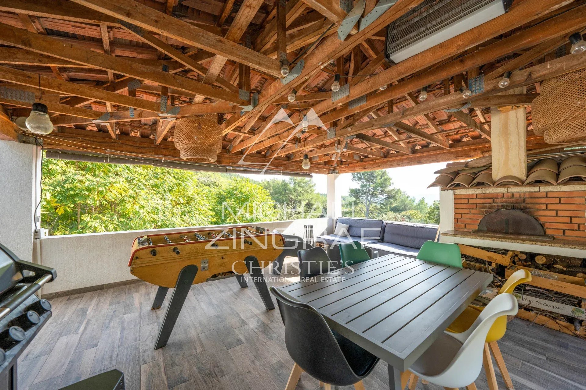 Terrasse avec barbecue et mobilier de jardin Terrasse couverte avec mobilier de jardin et barbecue dans une maison en pleine colline.