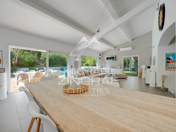 Intérieur d'une maison moderne avec un grand séjour lumineux et une cuisine ouverte.