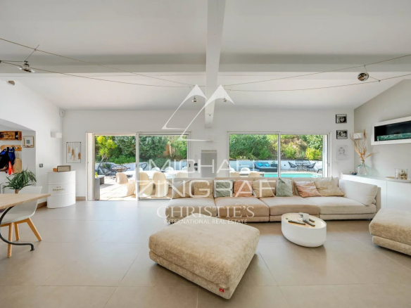 Intérieur d'une maison moderne avec un grand salon lumineux et un espace de vie ouvert.