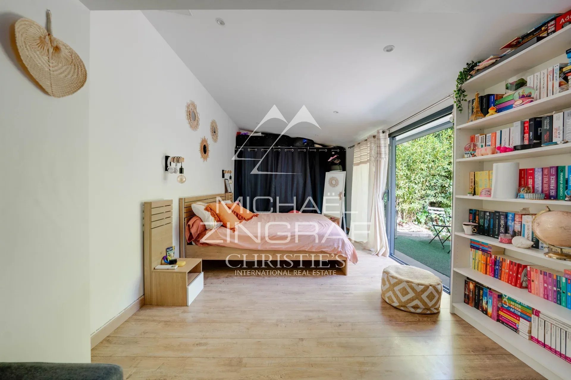 Intérieur d’une maison à Allauch Intérieur d'une maison avec lit, bibliothèque et accès à un jardin.