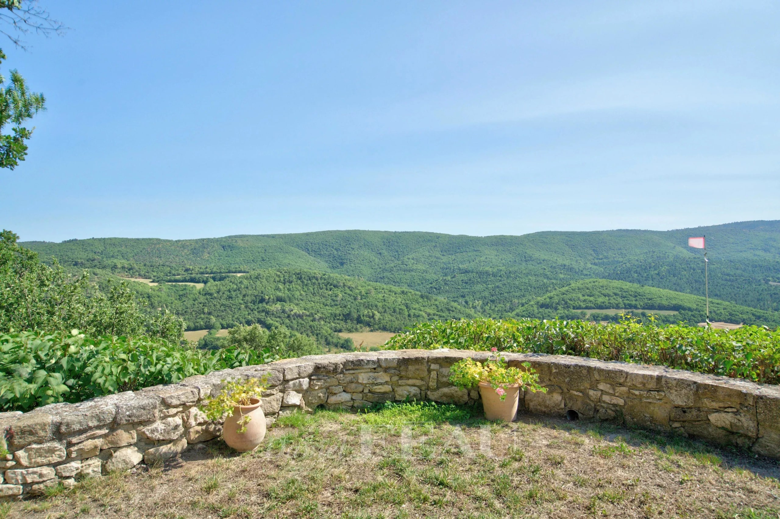 Panoramic view of green hills from a stone terrace.