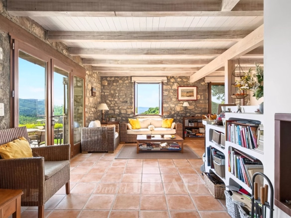Interior of a stone house with a bright living room and a view of nature.